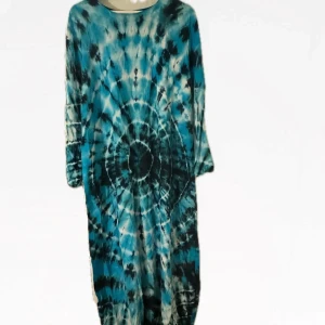 Mönstrad långklänning i blå och svart från Malaysia  - Säljer en cool långklänning med batikmönster i blått och svart. Klänningen har en avslappnad passform och långa ärmar, perfekt för en bohemisk stil. Den är tillverkad i ett mjukt och bekvämt material. Ej använd.