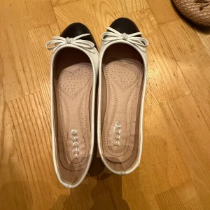 Svartvita ballerinaskor  - Säljer ett par stilrena ballerinaskor från croatien i svart och vitt. Skorna har en söt rosett på ovansidan och en bekväm innersula. Perfekta för en chic och avslappnad look. kom gärna med prisförslag😍