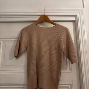 Säljer en mjuk och stilren beige kashmirtröja från H&M. Tröjan har en ribbad design och trekvartsärmar, perfekt för en elegant och bekväm look. Passar utmärkt till både vardag och mer uppklädda tillfällen.