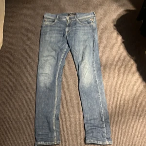 Blå jeans från Replay - Snygga blå jeans från Replay med en klassisk femficksdesign. De har en slim passform och är tillverkade i slitstarkt denim. Perfekta för en stilren look.längd w33