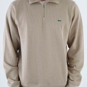 Lacoste Half Zip - Snygg tröja från Lacoste med halv dragkedja och med lacoste märket på bröstet. Perfekt för en stilren och grish look. Tröjan har långa ärmar och en bekväm passform.