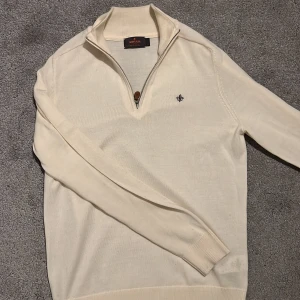 Off white tröja med dragkedja från Morris S - Extremt Snygg off white half zip från Morris med dragkedja och liten broderad logga på bröstet. Tröjan har långa ärmar och en stilren design som passar perfekt för både vardag och mer uppklädda tillfällen. Nypris ligger på ca 1799kr men mitt pris ligger på 750kr men går självklart att diskutera om!!