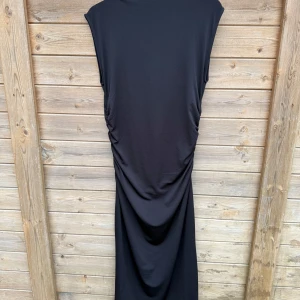 Svart långklänning - Svart lång klänning ifrån H&M med dragkedja på ena axeln, går lite in vid midjan. I storlek M 
