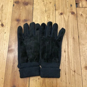 Svarta mocha habdskar - Säljer ett par svarta mocha handskar med ribbstickade muddar. De är tillverkade i ett mjukt material och har förstärkningar på fingertopparna. Perfekta för kalla dagar!