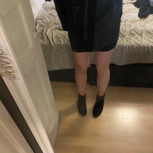 Svarta boots med klack - Snygga svarta boots med klack, perfekta för en stilren look. De har en spetsig tå och är tillverkade i ett elegant material som ger en sofistikerad touch.