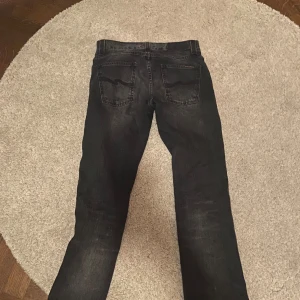 Svarta jeans Slim Jim - Snygga svarta jeans i modellen Slim Jim. Tillverkade av 100% bomull med en slim passform. Storlek 30/32, utan några som helst deffeker. Bara att höra av sig vid minsta lilla fråga eller fundering!