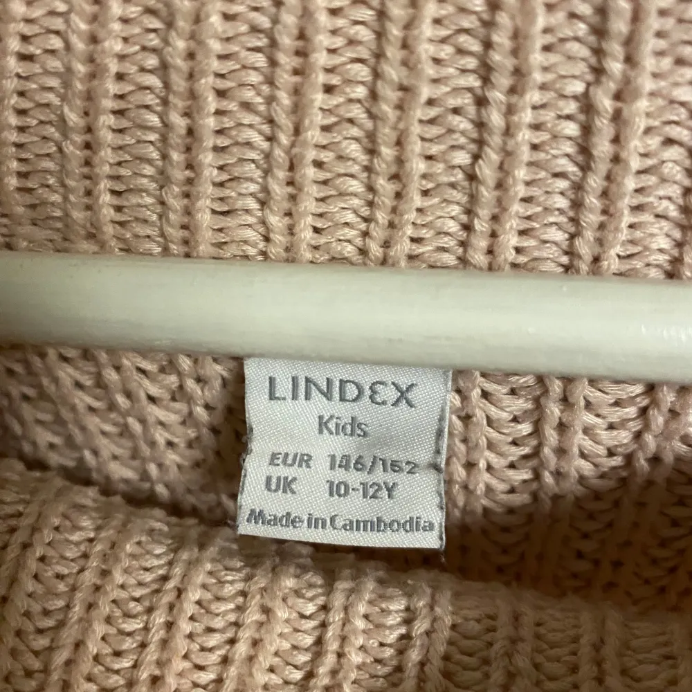 Säljer en mysig beige stickad tröja från Lindex för barn i storlek 146/152. Tröjan har en rund halsringning och långa ärmar, perfekt för kyligare dagar. Den är tillverkad i ett mjukt och bekvämt material som håller värmen bra. Perfekt för höst och vinter! 🍂❄️. Neuletakit & Villapaidat.
