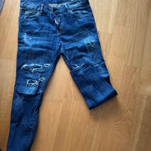 Blå jeans från Dsquared2 - Snygga blå jeans från Dsquared2 med slitna detaljer och en cool, avslappnad look. De har en klassisk femficksdesign och en läderpatch med logotyp baktill. Perfekta för en trendig stil.