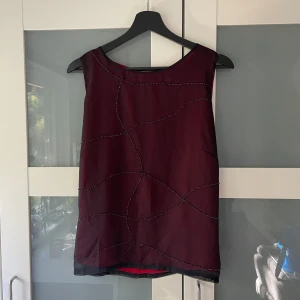 Topp - Så snygg svart/röd, vad jag tror; är en vintage Lindex-topp! I storlek 44 alltså L/Xl, på bild sen ni hur den sitter på mig som är ca M!  I mycket fint skick, pärldetaljer fram, dragkedja bak. 