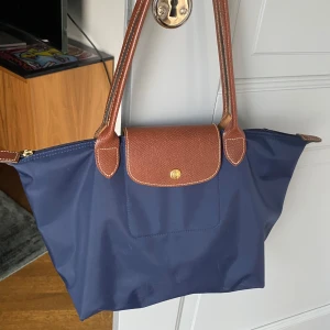 Longchamp väska - Jätte fin longchamp väska i mörkblå! Lite sliten i kanterna (se bild 3) men inget man tänker på!🩷