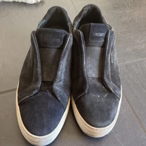 Svarta sneakers från Axel Arigato - Säljer ett par svarta sneakers från Axel Arigato. Det är storlek 42 skicket är bra bara att dem är lite smutsiga men det går lätt att fixa. Har ingen box eller kvitto. 