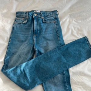Blå jeans från Zara - Säljer ett par snygga blå jeans från Zara. De är i en klassisk blå färg och har en cool slitsdetalj vid benslutet. Perfekta för en casual look och passar till det mesta. De är i storlek 36 och har en bekväm passform.