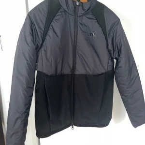 Grå/svårt J.Lindeberg jacka - Oanvänd J.Lindeberg Sanaa Hybrid Jacket. Nypris 2000kr säljer för 400kr!