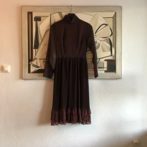 Brun vintage klänning  - En superfin brun skräddarsydd vintageklänning. Dragkedja bak. Uppskattad strl 34