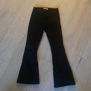 Säljer ett par svarta bootcut byxor från Lindex i storlek EUR 140 / UK 9-10Y. Byxorna har en snygg och klassisk bootcut-stil som ger en fin siluett. Perfekta för både vardag och festliga tillfällen!