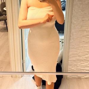 Vit ribbad klänning - Snygg vit ribbad klänning med axelbandslös design och en liten slits på sidan. Perfekt för en stilren look. Passar perfekt för s/m/l storlek 