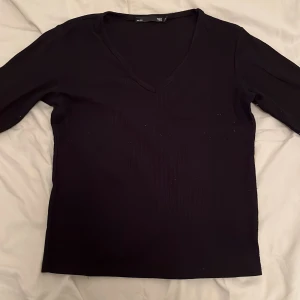 Svart v-ringad tröja från 157 - Säljer en stilren svart tröja från 157 med v-ringning. Perfekt för en enkel och elegant look. Tröjan har trekvartsärmar och är i en bekväm passform.