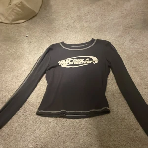 Grå långärmad tröja med tryck/ szara koszula z długim rękawem i nadrukiem - Snygg svart långärmad topp med tryck i vitt. Den har kontrastsömmar vid ärmslut och nederkant som ger en cool look. Perfekt för en avslappnad stil. 