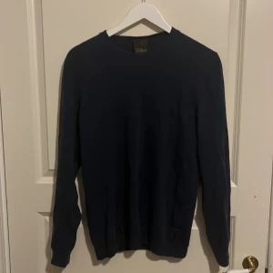 Mörkblå tröja från Oscar Jacobson - Säljer en stilren mörkblå tröja från Oscar Jacobson. Tröjan är storlek L men skulle även passa M. Inga slitningar eller skador på tröjan. 