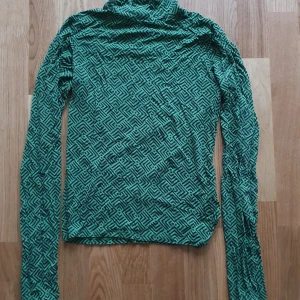Oanvänd - Grön mönstrad top - Snygg grön polo top i lite kraftigare trikå. Aldrig använd,  stl S