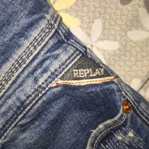 Blå jeans från Replay - Snygga blå jeans från Replay med slitna detaljer och en klassisk femficksdesign. Perfekta för en avslappnad stil. Storlek är 158