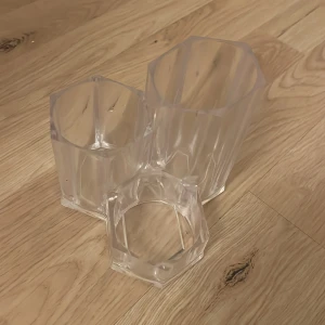 Transparenta hexagonala förvaringsbehållare - Säljer ett set med tre transparenta förvaringsbehållare i hexagonal form. Perfekta för att organisera småsaker på skrivbordet eller i badrummet. De är stapelbara och tillverkade i klar plast för enkel överblick av innehållet.