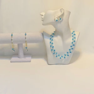 Blått och vitt smyckeset Jewelry A.J.D.Y  - Elegant smyckeset med halsband, armband och örhängen i blått och vitt. Setet har pärldetaljer och en glittrig finish, perfekt för att ge en färgklick till din outfit. Ett par örhängen och ett par armband plus en halsband handgjorda mycket mycket fint nytt oanvänd 