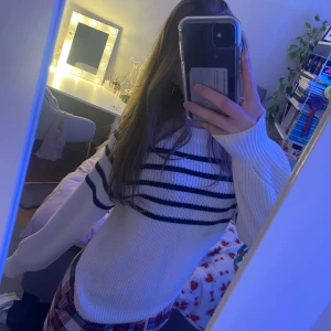 Vit och svart randig stickad tröja - Säljer en mysig vit stickad tröja med svarta ränder. Tröjan har långa ärmar och en rund halsring!💕