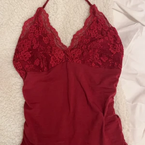 Vinröd halterneckstopp  - Vinröd halterneckstopp me spets å knyt i nacken