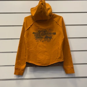 Koola Anna Kofta y2k grunge - Unik kofta ifrån märket Koola Anna med tryck på baksidan. Färgen på bilderna är för ljus men i verkligheten påminner färgen om en apelsin. Storlek Small utan skador.