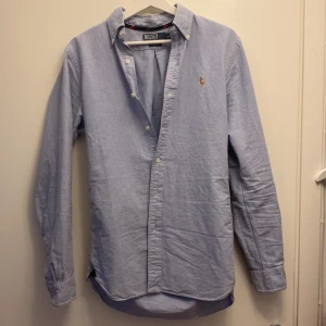 Ralph Lauren skjorta - Snygg ljusblå skjorta från Ralph Lauren i slim fit. Skjortan är i princip aldrig använd utan bara testad. Riktigt fet skjorta som går att styla med mycket annat. Perfekt för en stilren look