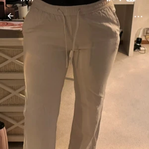 Beige linnebyxor från Madlady - Säljer ett par bekväma beige byxor från Madlady i storlek XS. Byxorna har en elastisk midja med snörning för justerbar passform. Perfekta för en avslappnad stil.