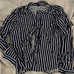 Randig skjorta i blått och vitt - Snygg blårandig skjorta, endast använd ett fåtal gånger och bra skick.