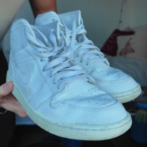 Vita Nike Air Jordans - Säljer ett par klassiska vita Nike Air Jordans med hög snörning och ikonisk design. 