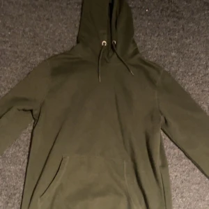 Grön hoodie från 157 - Säljer en grön hoodie från 157 i storlek S. Den har en klassisk design med dragsko i huvan och en stor ficka framtill. Perfekt för en avslappnad stil❤️