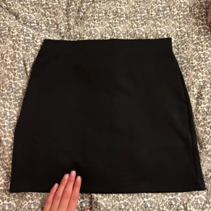 Svart minikjol - Snygg svart minikjol från hm strl s. Tjock och bra i materialet! 