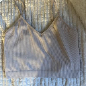 Beige ribbad linnetopp - Snygg beige ribbad linnetopp med smala axelband och v-ringning. Perfekt för en avslappnad stil.