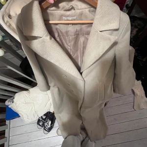Beige lång kappa  - En lång kappa som går ner typ till fötterna, från Josefine hj ’s kollektion med NA-KD. Supersnygg och passar till allt men har för många kappor. Den har några fläckar, se sista bild. Går nog bort ganska lätt, jag har bara inte pallat… Första bilden visar färgen bäst!