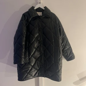 Svart quiltad kappa från Stand Studio - Snygg svart quiltad kappa från Stand Studio med knappar framtill. Stl 38/M