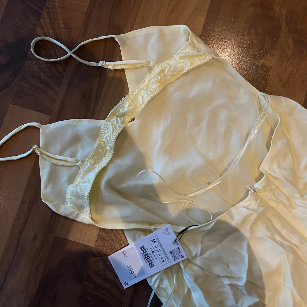 Ljusgul klänning från Zara. Aldrig använd. Klänningen har en mjuk och glansig yta, perfekt för sommarens festligheter. . Mekot.