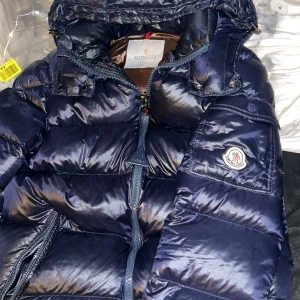 Moncler Maya - Storlek 1, skick: 8/10 använd ett par gånger. Säljer pågrund av att jag vuxit ur den. Jackan har inga defekter. Kontakta för fler bilder på den eller frågor.