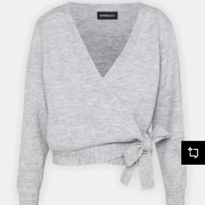 Grå omlottkofta från Even&Odd - Snygg och bekväm grå omlottkofta från Even&Odd. Den har en v-ringad design och knytning i midjan för en stilren look. Perfekt för lager-på-lager under kyligare dagar. Andvänd en gång så i nyskick
