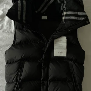 Burberry väst (äkta)  - Säljer en Burberry-jacka som jag fått i present. Jackan är endast använd två gånger då den är för stor för mig. Nypris är cirka 17 000 kr och den är i nyskick (10/10) utan defekter.  Originalförpackning från NK medföljer, inklusive kvitto, påse och alla tillbehör. Jag kan tänka mig att justera priset vid en snabb affär.  Vid frågor eller intresse är ni varmt välkomna att höra av er.