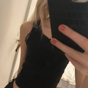 Svart linne från BikBok - Säljer ett svart linne i storlek S från BikBok med spetsdetaljer vid axelbanden.