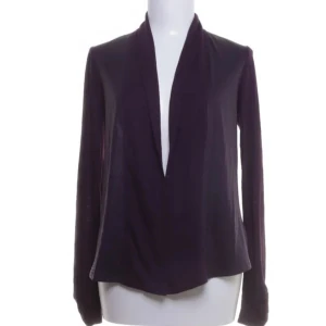 Lila tröja från Calvin Klein - Snygg lila tröja från Calvin Klein i en mjuk polyesterblandning. Tröjan har en elegant draperad design framtill och långa ärmar. Perfekt för en stilren look.