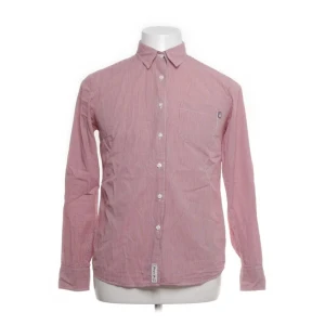 Röd- och vitrandig skjorta från Lexington - Snygg röd- och vitrandig skjorta från Lexington i 100% bomull. Skjortan har långa ärmar och knappar framtill samt en bröstficka. Perfekt för en stilren look.