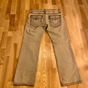 True Religion Jeans - Lågmidjade Truey jeans, i bra skick utan märkbara tecken på användning. Dom sitter loose och är riktigt sköna. Det står att de är i storlek 38 men de passar mig som brukar 30-32 om jag använder bälte. Skriv om du har frågor, pris kan diskuteras!