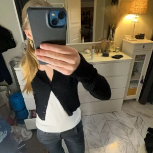 Svart kofta från Lindex - Säljer en stilren svart kofta från Lindex. Den har en klassisk design med knappar framtill och långa ärmar. Perfekt för lager-på-lager-stil. Skriv vid frågor eller intresse💞💞(liten defekt vid ena armen kan skicka bild privat)