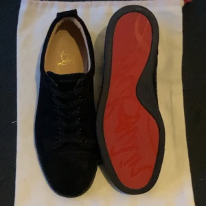 Svarta Louboutin Skor  - Hej! Säljer ett par snygga svarta sneakers från Christian Louboutin i mocka med den ikoniska röda sulan. Skicket på skorna är 9/10 då dom används ett fåtal gånger men är precis som nya! Perfekta för ge din outfit en lyxig touch!. Pris kan diskuteras vid snabb affär inte ristat i sten.