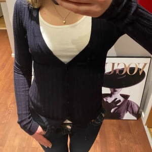 Svart ribbad kofta från Gina Tricot - Snygg svart ribbad kofta från Gina Tricot med knappar framtill. Perfekt för lager-på-lager.